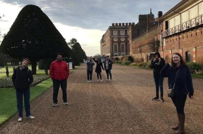 Students stand in a driveway of a vast estate in the UK.