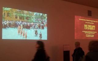 Two projected images on a gallery wall.