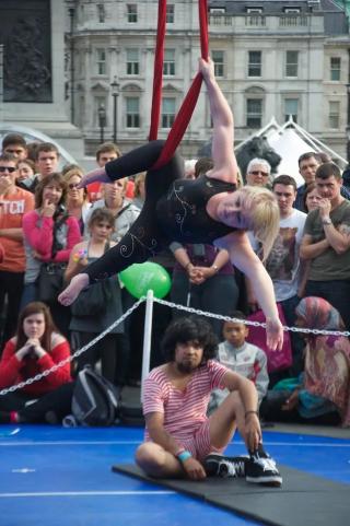An acrobat dancer performs for a crowd outside.