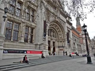 People sit on the steps outside of a museum in London.