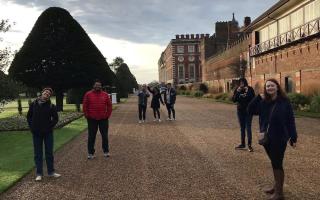 Students stand in a gravel driveway of an English estate in the UK.